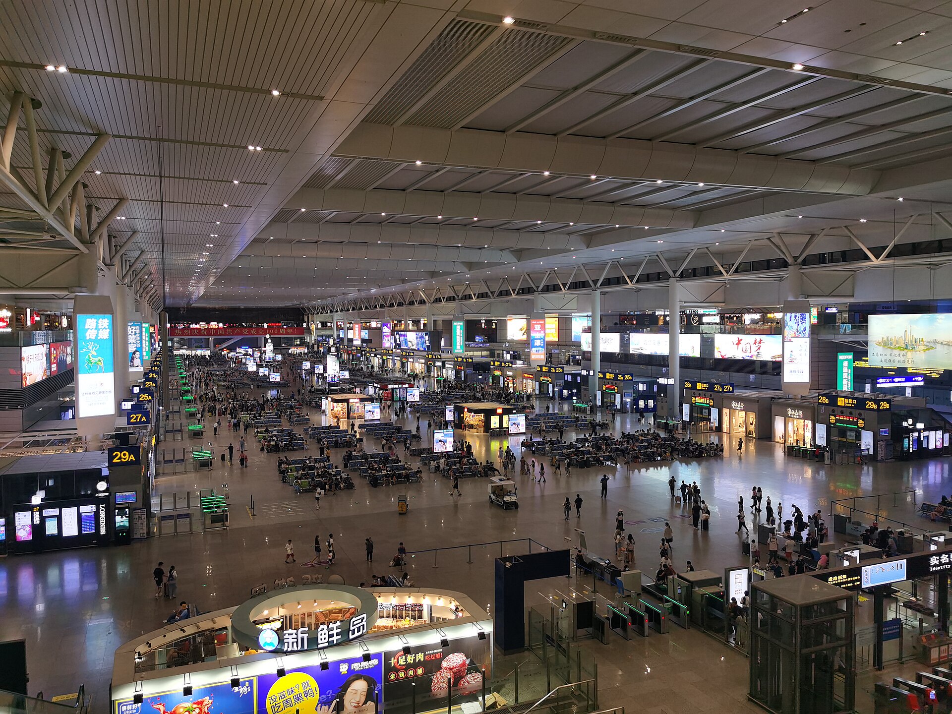 Elevated view across the waiting concourse and numbered gates at Shanghai Hongqiao Railway Station in July 2021.