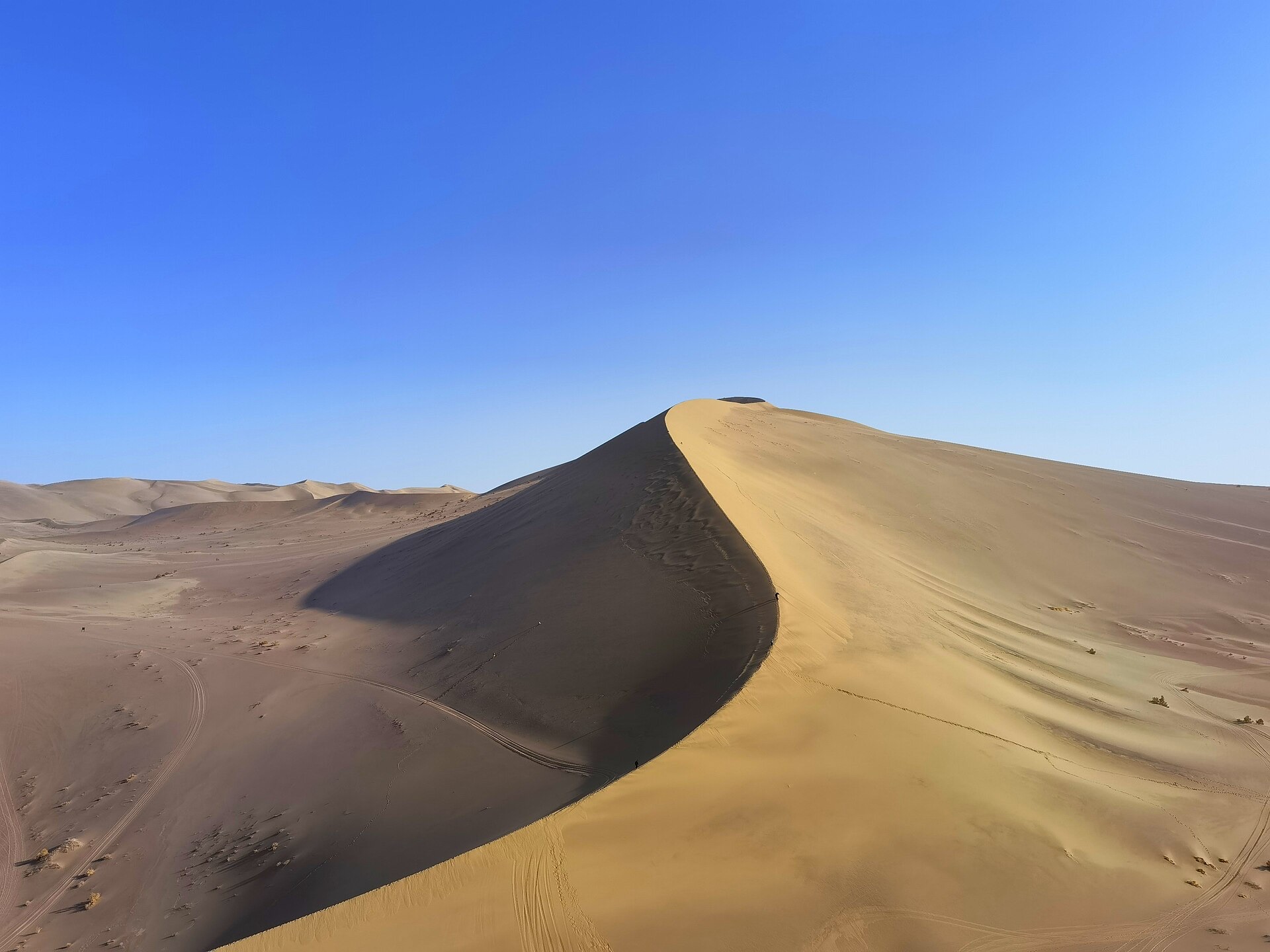 Sunlit sand dunes at Mingsha Mountain in Dunhuang